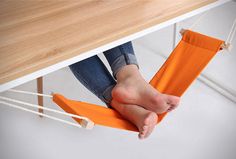 a woman is sitting in a hammock with her feet on the table