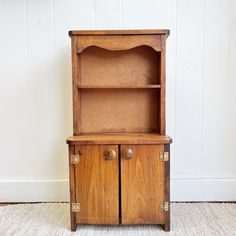 an old wooden cabinet with two doors on the front and one door open to reveal a shelf