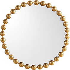 a round mirror with gold balls around it