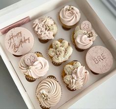 a box filled with lots of cupcakes on top of a white countertop