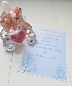 a greeting card with a heart and two pieces of glass on it next to a note