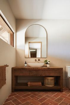 a bathroom with a sink, mirror and toilet