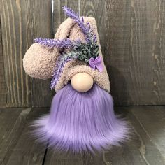 a stuffed animal with purple hair and a hat