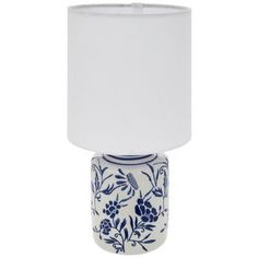 a blue and white vase lamp with a white shade on the top, in front of a white background