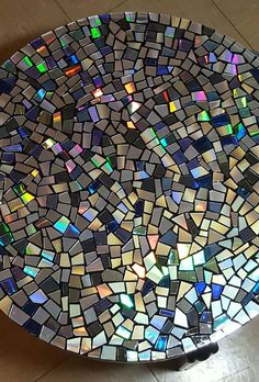 a mosaic glass plate sitting on top of a tiled floor