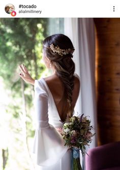 the back of a woman's head wearing a white dress and holding a bouquet