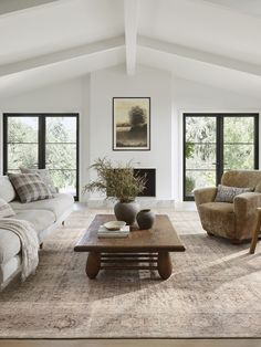 a living room with two couches and a coffee table in front of the fireplace