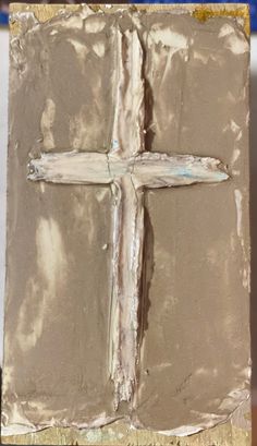 a close up of a cross made out of clay