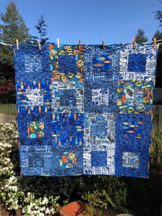 a blue quilt hanging on a clothes line