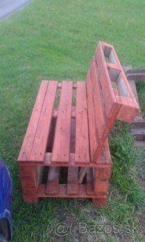 a bench made out of wooden pallets sitting in the grass next to a blue car