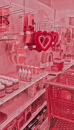 a red shopping cart in a store filled with lots of love shaped items on shelves