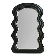 a mirror that is black and white with wavy lines on the edges, as well as an oval shaped frame