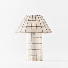 a lamp that is on top of a white tablecloth covered flooring with squares