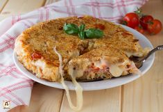 a pizza with cheese and tomato sauce on a white plate next to a red checkered napkin