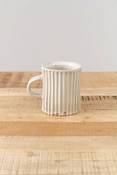 a white cup sitting on top of a wooden table