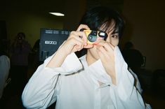 a young man holding up two cell phones to his face