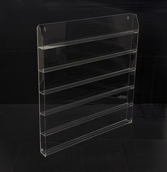 three tiered clear acrylic display case on black background with clippings