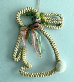 an ornament made out of rope with flowers hanging from it's side