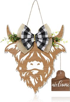 a wooden sign with a buffalo head and bow tie hanging from it's side