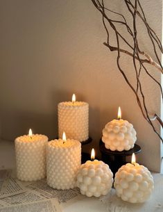 five white candles sitting on top of a table