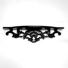 a black and white photo of a shelf with an ornate design on the top, against a white background