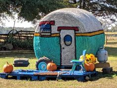 a large hay bale sitting in the middle of a field next to pumpkins