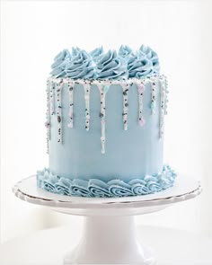 a blue cake with icing on the top and frosting dripping down the side