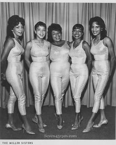 four women in white outfits posing for a photo