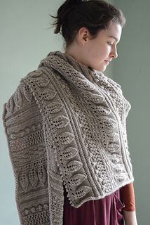 a woman wearing a knitted shawl with an openwork design on the back