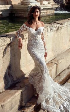 a woman in a wedding dress leaning against a wall