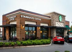 a starbucks coffee shop with cars parked in front