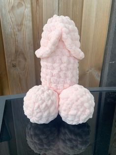 a pink stuffed animal sitting on top of a glass table