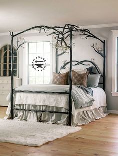 a bedroom with a canopy bed and white rugs on the wooden floor next to it