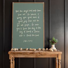 a wooden table topped with a green chalkboard next to a potted plant