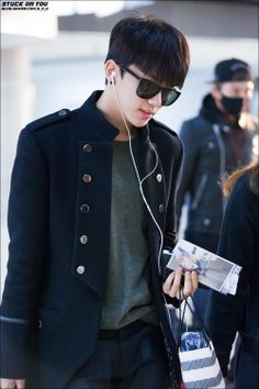 a young man wearing headphones and carrying a bag