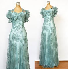 "Beautiful turquoise evening dress from the 1940's. Floor length gown in the classic 40's silhouette, long and narrow with a tiny waist and full skirt. Sheer chiffon fabric with velvet flocking, ruched bodice and pink and aqua velvet flower details. Dramatic puff sleeves and button back closure. Good condition, with a few small holes near the hemline as shown in the last photos. A gorgeous true vintage gown for a Hollywood starlet.   MEASUREMENTS: Bust: 32\" Waist: 25\" Hip: 34\"  Length: 60\" SIZE No Label Fits like Size Small CONDITION GOOD - Wearable with a few minor imperfections To view more vintage dresses, follow the link below to my shop: https://www.MinkyVintage.etsy.com" 1940 Formal Dress Evening Gowns, 40s Formal Dress, Turquise Dress, 1940s Evening Gowns, 40s Dresses Vintage, 1920s Fashion Dresses, Hollywood Starlet, Velvet Flower, Dress Puff Sleeve