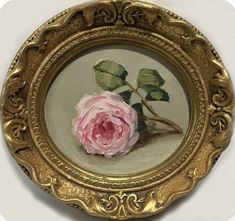 a painting of a pink rose in a gold frame