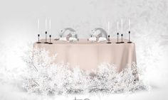 an image of a table setting for two with silverware on it and frosted trees in the background