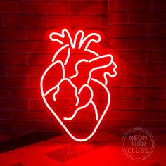 a neon heart sign on a brick wall