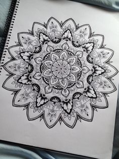 a drawing of a flower in black and white on a spiral bound notebook with pen