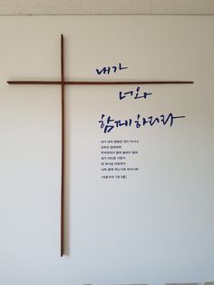 a cross with writing on the wall above it