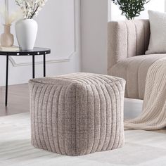 a living room scene with focus on the footstool and rugs in the foreground