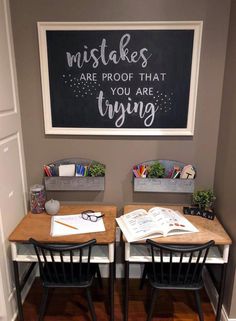 two desks with chairs and a chalkboard on the wall above them that says, make