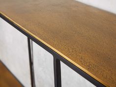 a close up of a counter top with metal bars on the bottom and white walls in the background