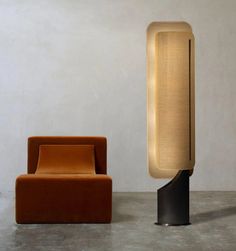 an orange chair next to a black and white lamp