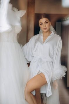 Make your wedding day morning even more special with our short silk wedding robe with feathers. Crafted from high-quality silk, this luxurious bridal robe is designed to make every bride feel elegant and comfortable as she prepares for her big day. The delicate feathers adorning the cuffs add a touch of glamour and uniqueness, making it a stunning choice for your wedding day photos.  * Length 85-90 cm / 33-35 in * Handmade * High-quality soft Armani silk * Made to measure * Feathers on buttons ( Elegant Robe With Feather Trim For Wedding Night, Feathered Robe For Wedding Night, Elegant Wedding Robe With Feathers, Wedding Satin Robe With Feathers, Elegant Wedding Night Dress With Feather Trim, Elegant Feather Trim Dress For Wedding Night, Feathered Dresses For Wedding Night, Satin Wedding Dress With Feather Trim, Wedding Satin Dress With Feather Trim