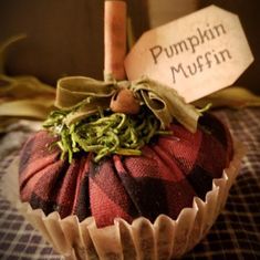 a small pumpkin sitting on top of a table next to a sign that says pumpkin muffins