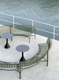 four benches and two tables on the side of a boat in front of some water