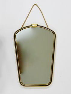 a mirror hanging from a rope on the wall