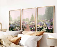 three paintings hang on the wall above a bed